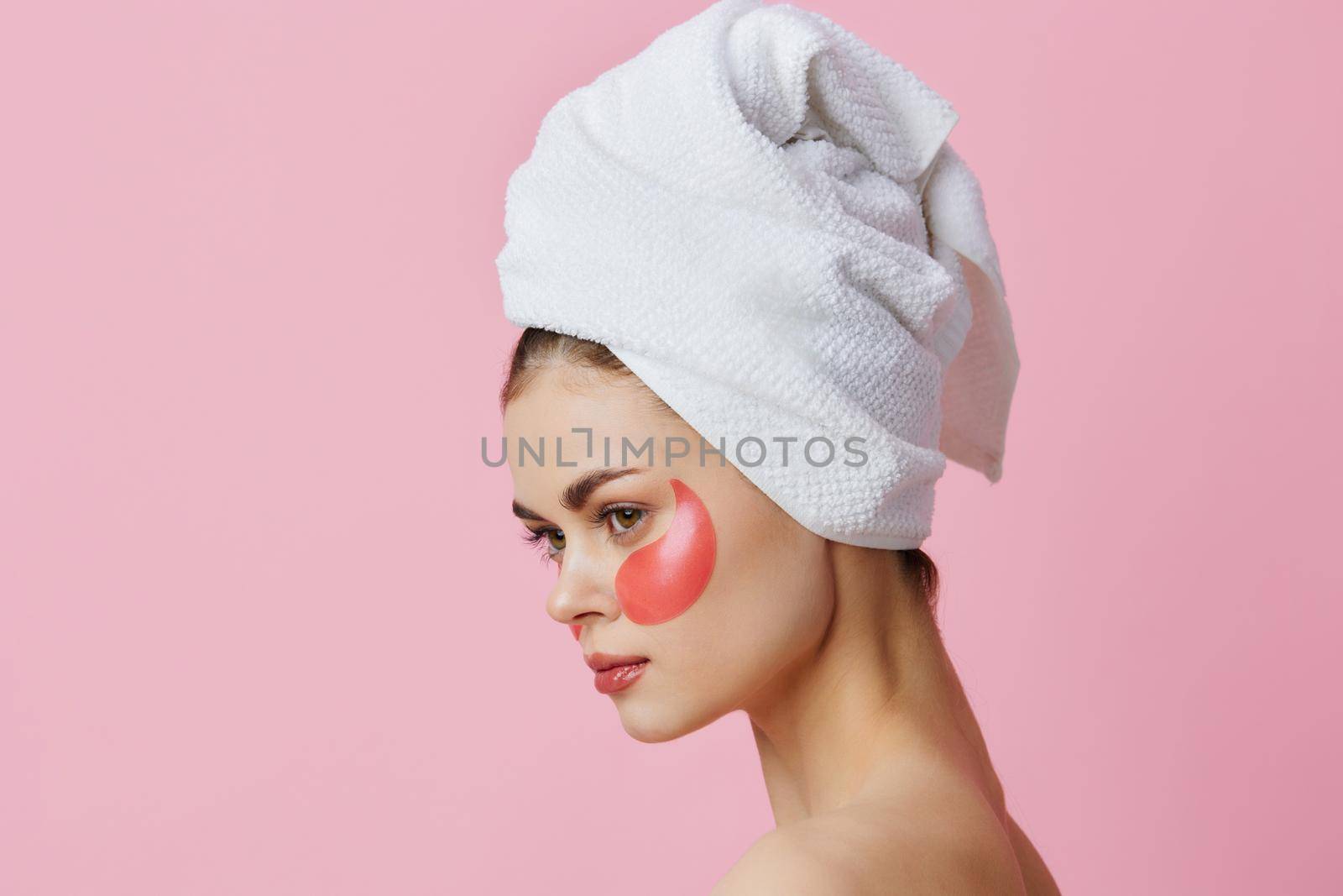 young woman pink patches on the face with a towel on the head isolated background by SHOTPRIME