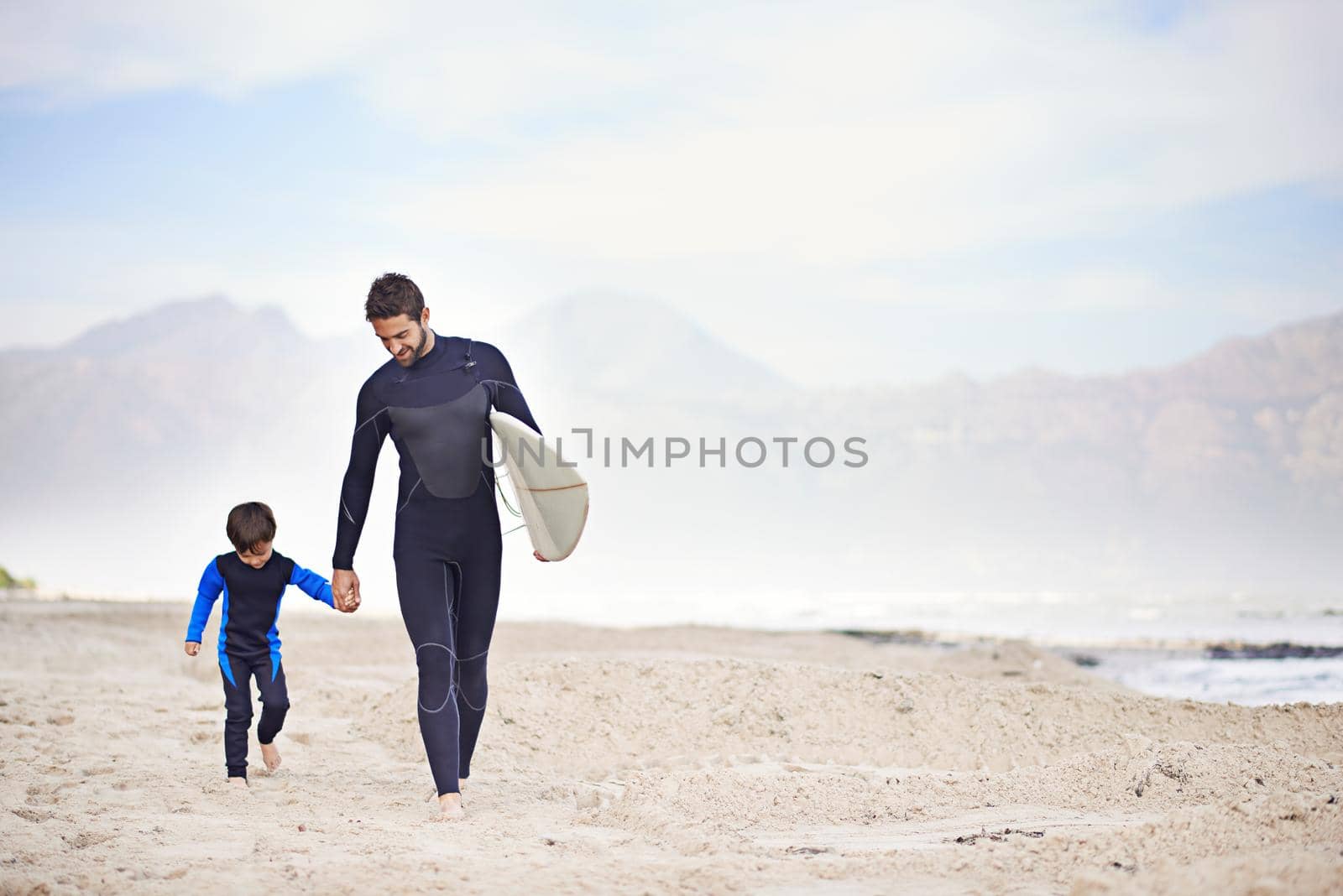 Sharing a passion for surfing with his son. Shjot of a father and son enjoying a day outdoors. by YuriArcurs