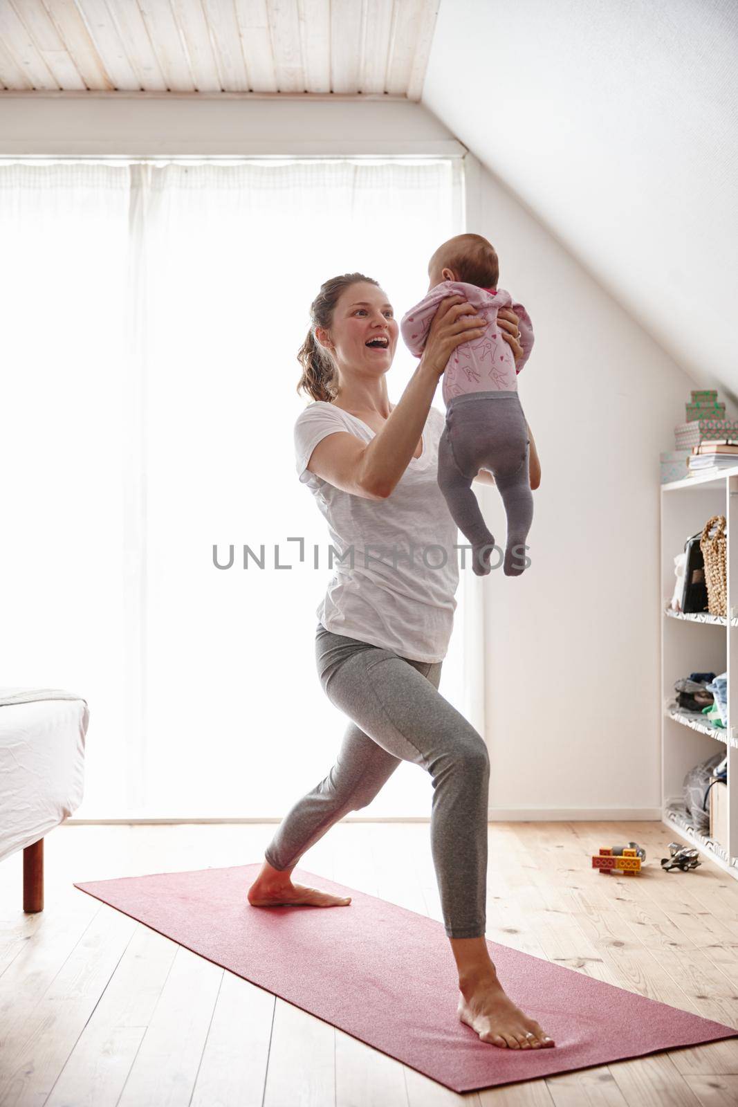 Body conscious mom and baby. Shot of an attractive young woman bonding with her baby girl while doing yoga. by YuriArcurs