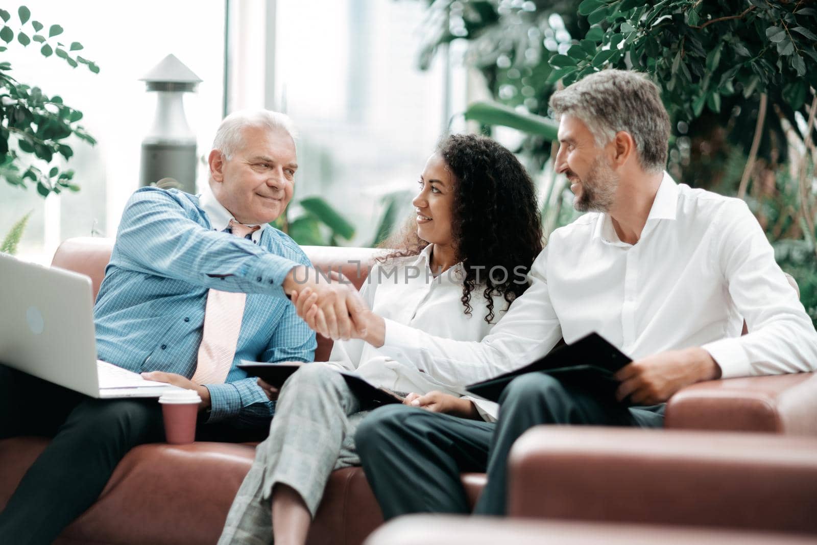 business partners shaking hands at a working meeting. by SmartPhotoLab