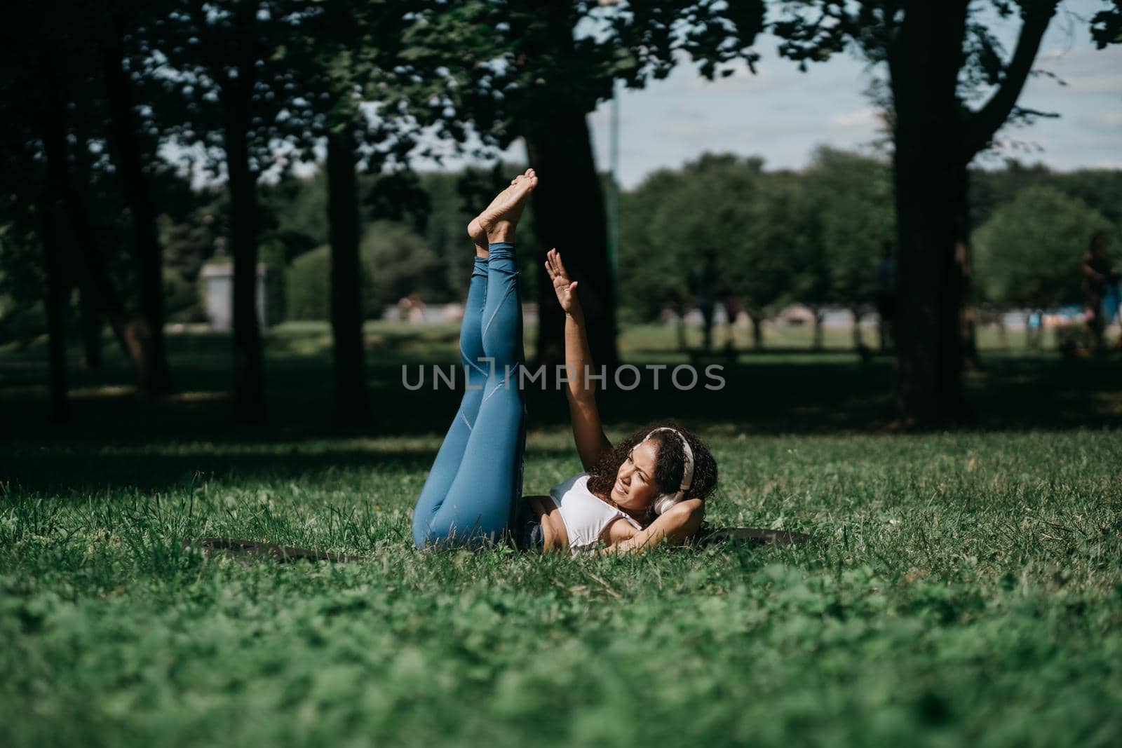 sporty young woman doing exercises in the city park . by SmartPhotoLab