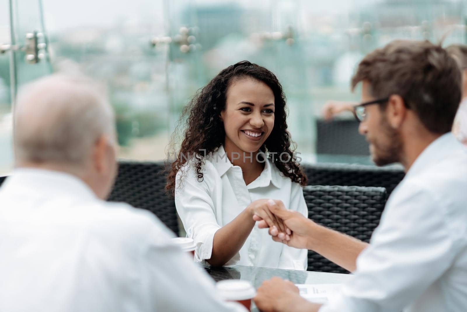 smiling business colleagues shaking hands. close up. by SmartPhotoLab