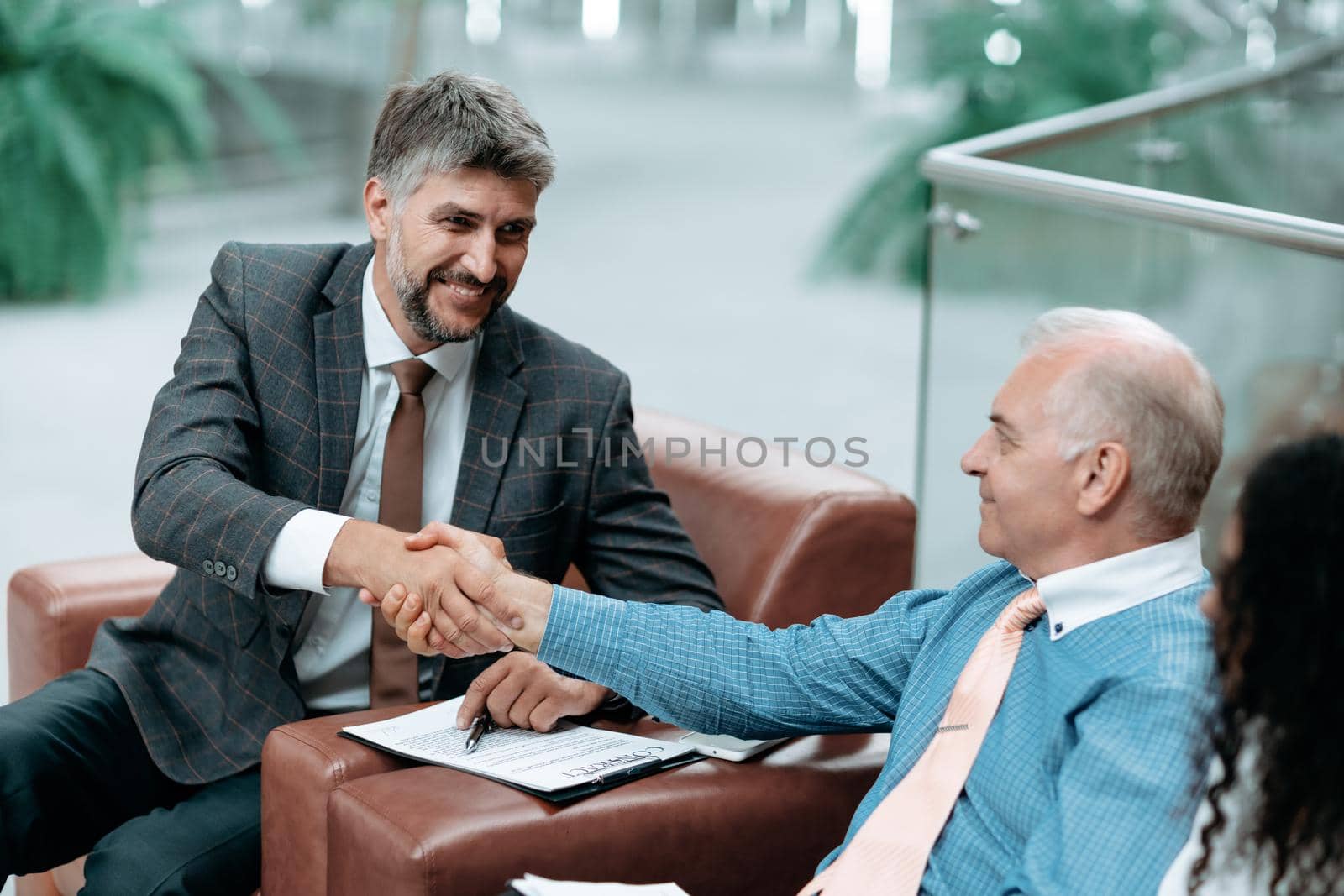 business people shaking hands after signing a contract. by SmartPhotoLab