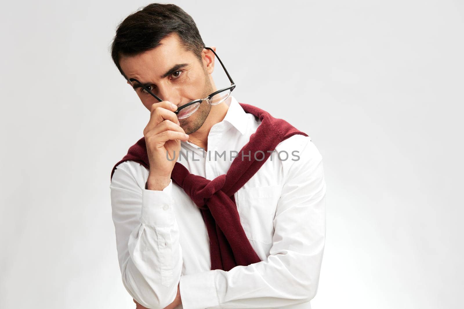 successful man in a white shirt sweater on the shoulders pensive look glasses light background by SHOTPRIME