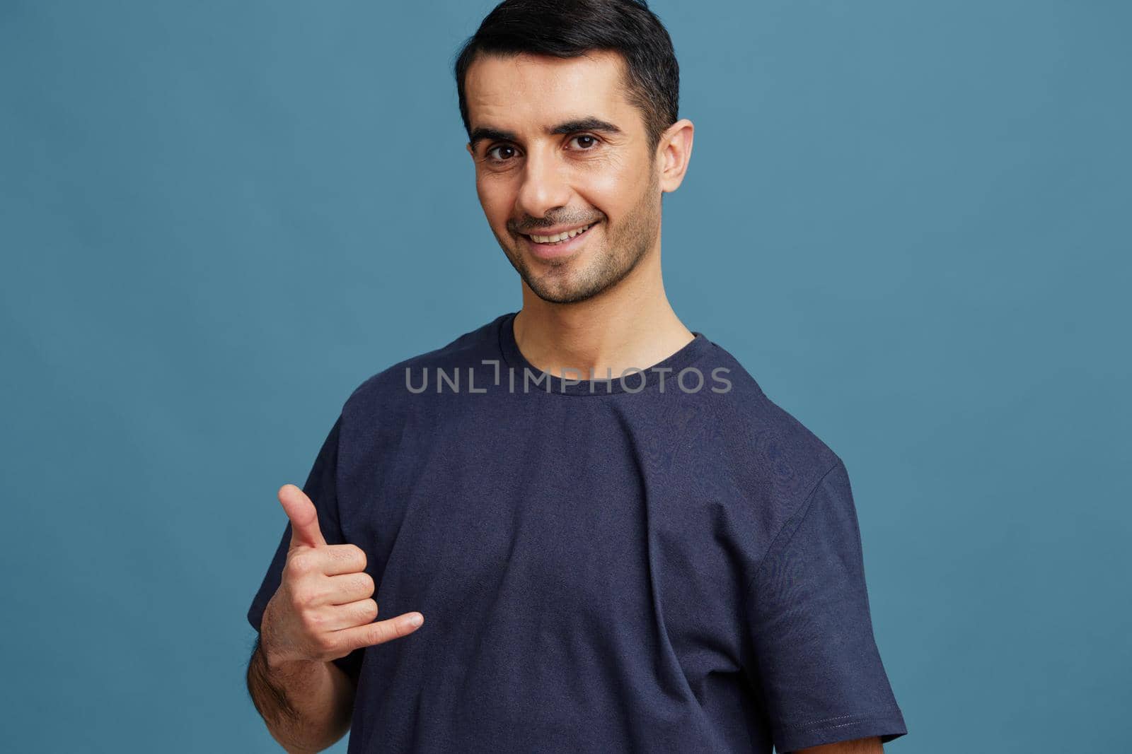 smiling man gesture with hands blue t-shirt casual wear by SHOTPRIME