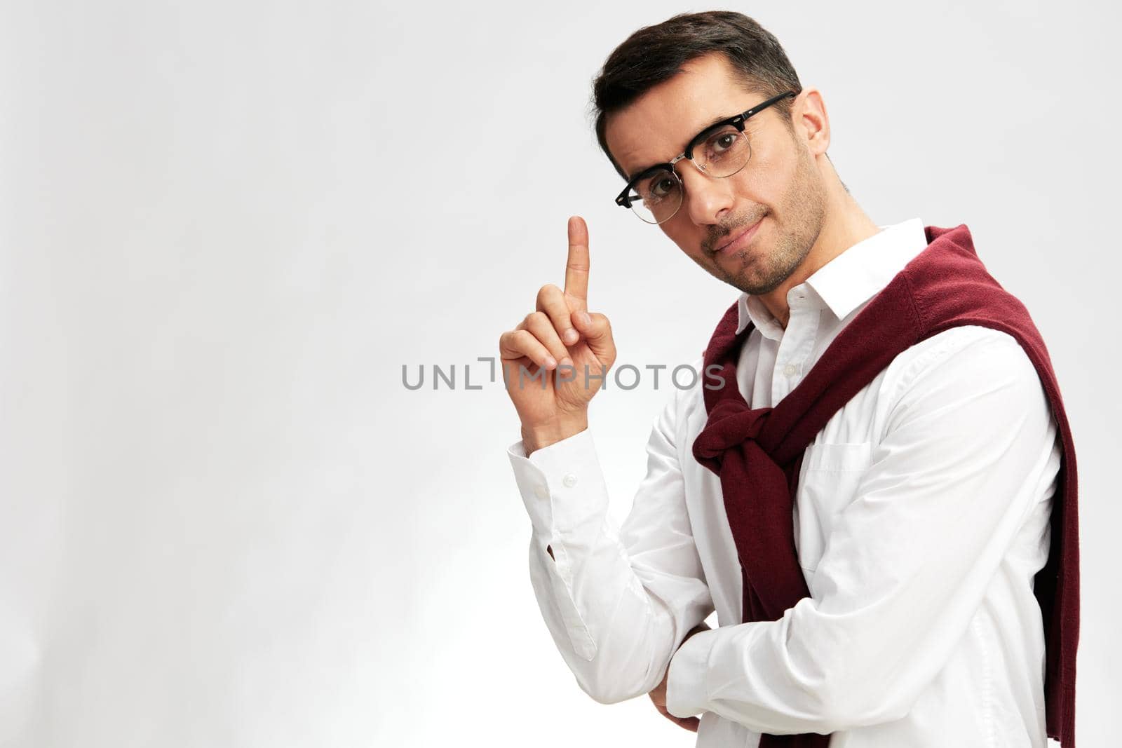 handsome businessman in a white shirt sweater on the shoulders pensive look glasses isolated background. High quality photo