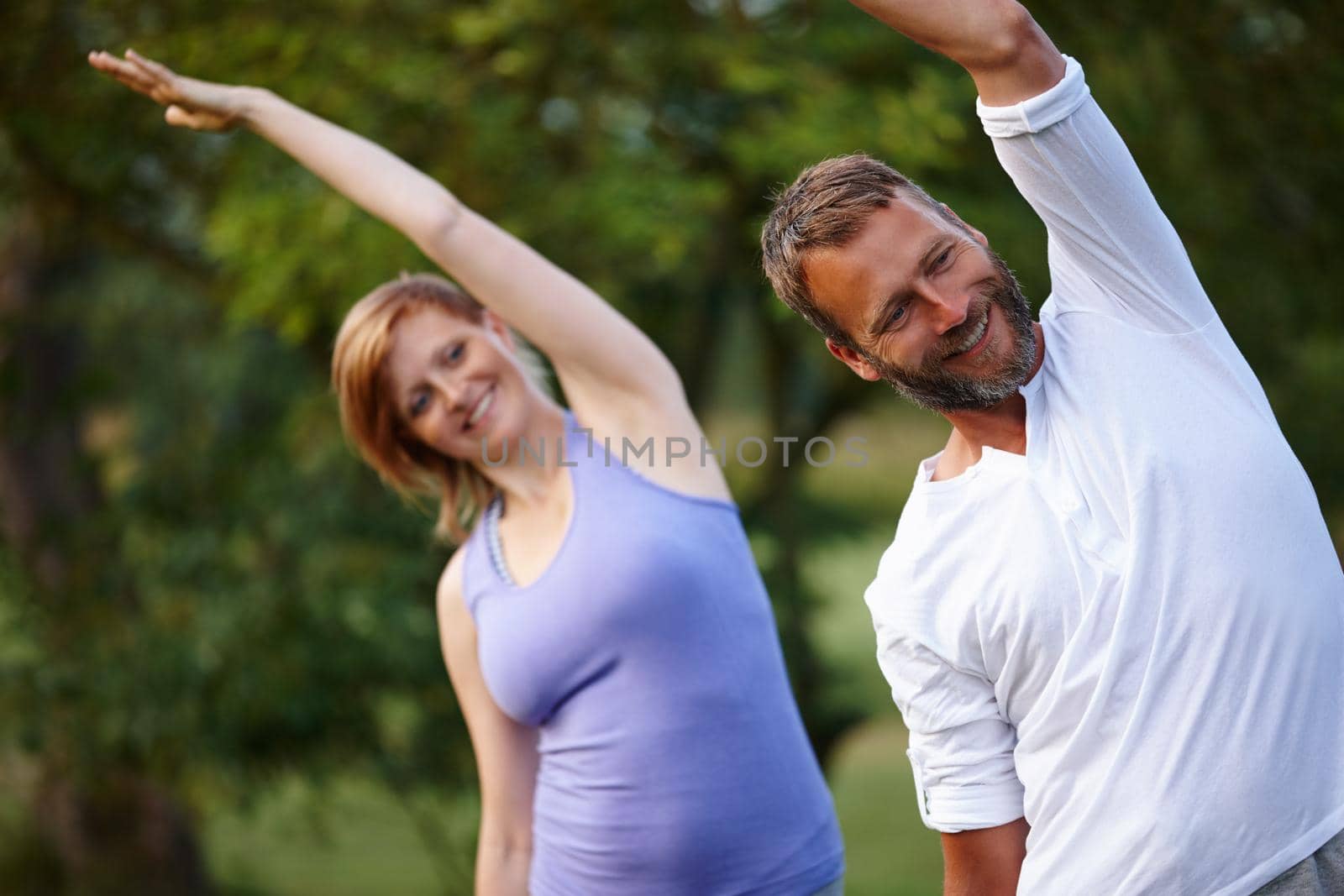 Shot of a happy mature couple doing yoga in nature.