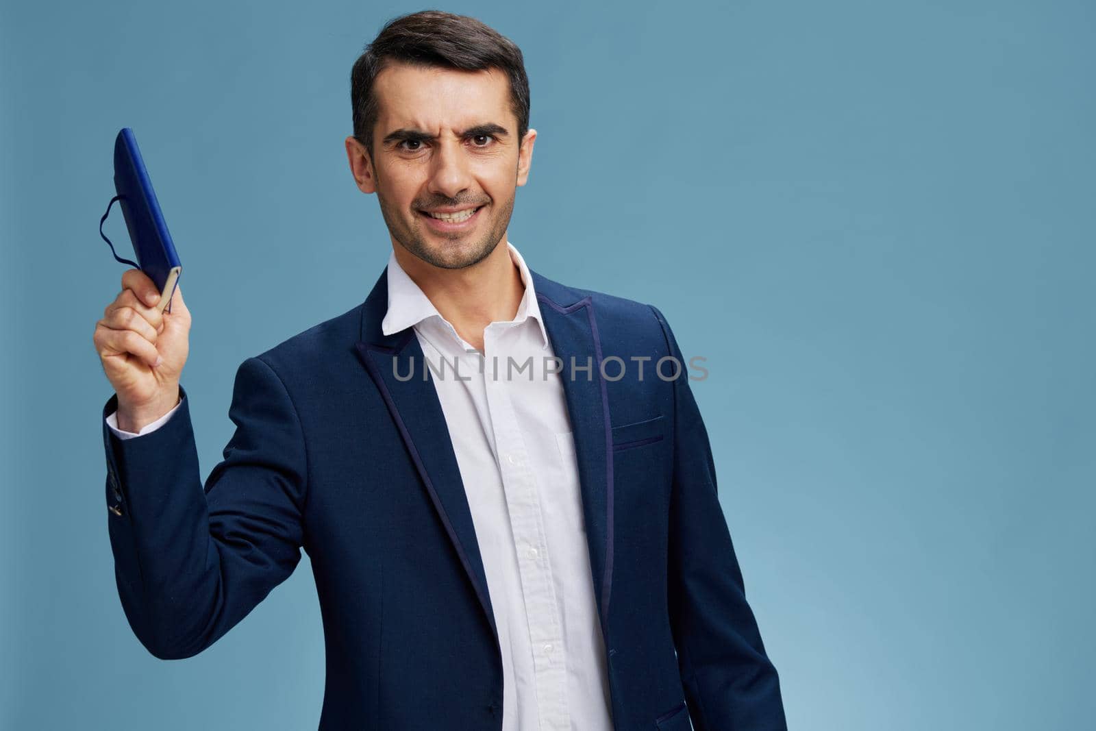 successful man with a notepad in handfinancial report work self-confidence blue background. Copy space by SHOTPRIME