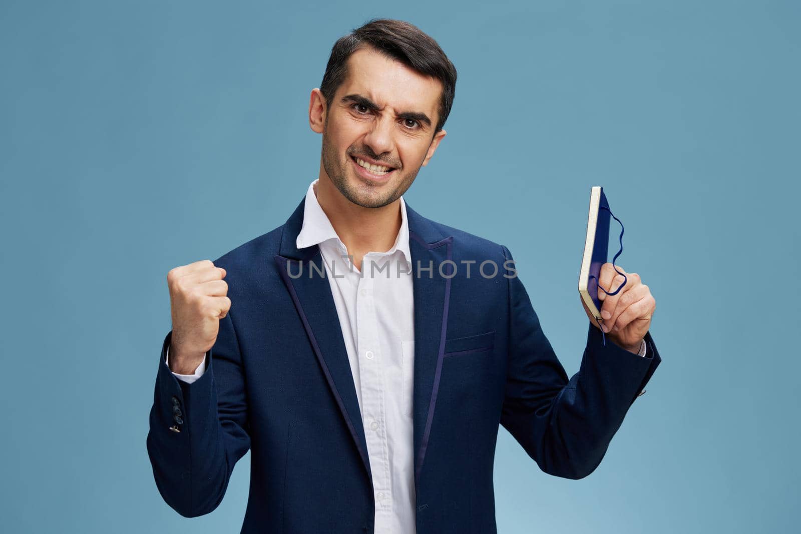 manager with a notepad in hand clenched his fists with an angry look isolated background. Copy space. High quality photo