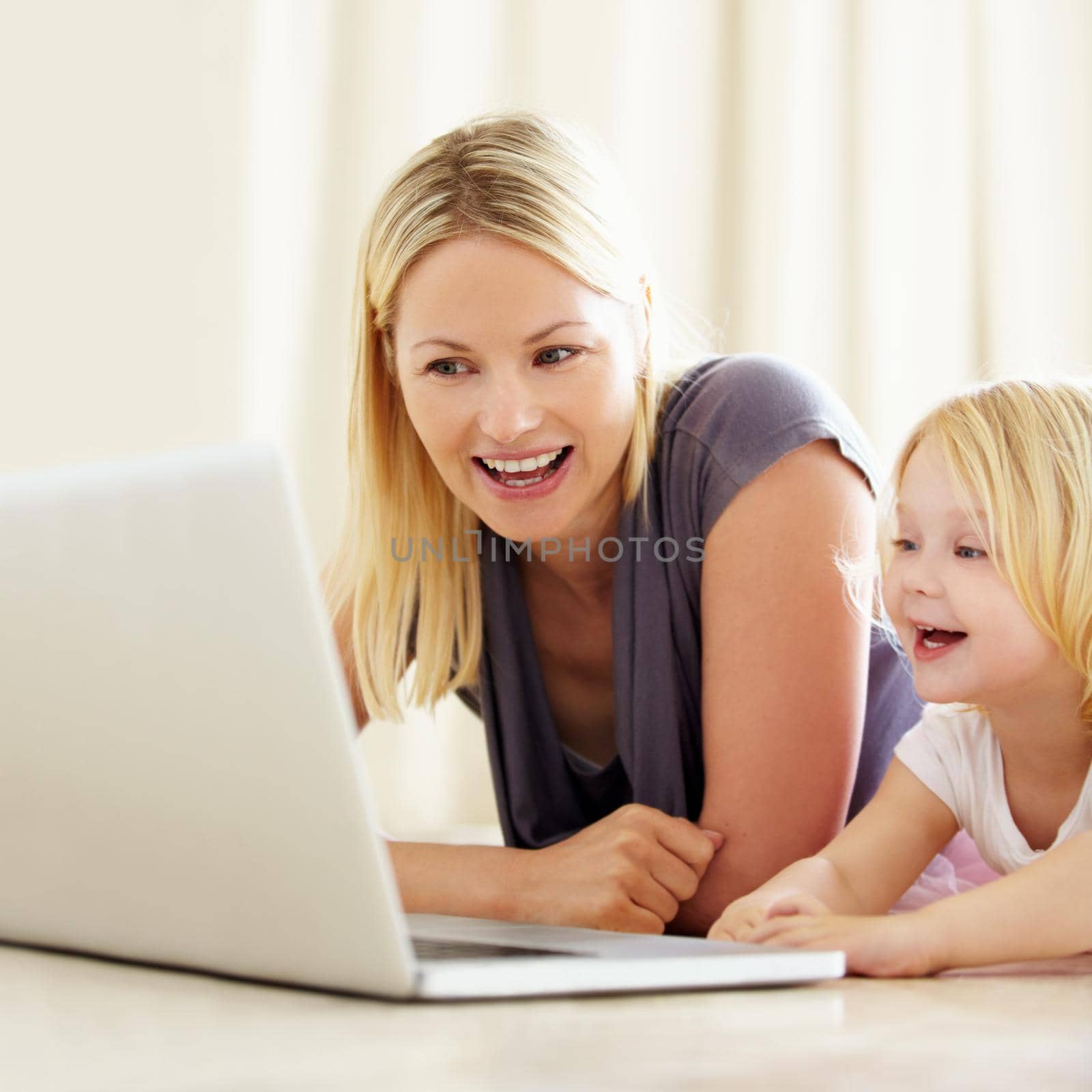 She loves watching cartoons online. Shot of a mother and daughter bonding while surfing the internet together. by YuriArcurs