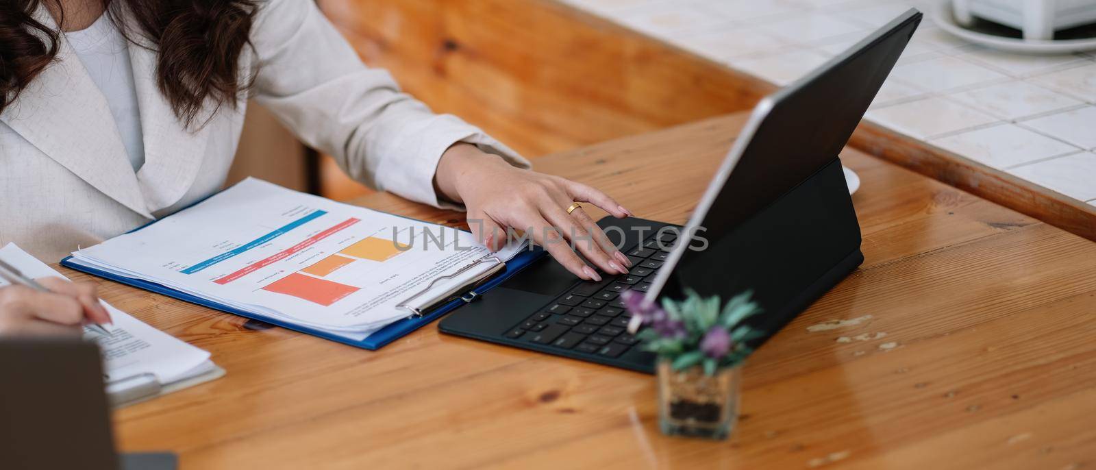 Close up of businesswomen or accountant using laptop computer while working analytic business report on the workplace, Planning financial and accounting concept.