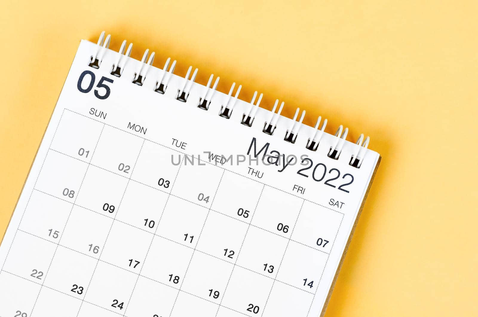 The May 2022 desk calendar on light yellow background.
