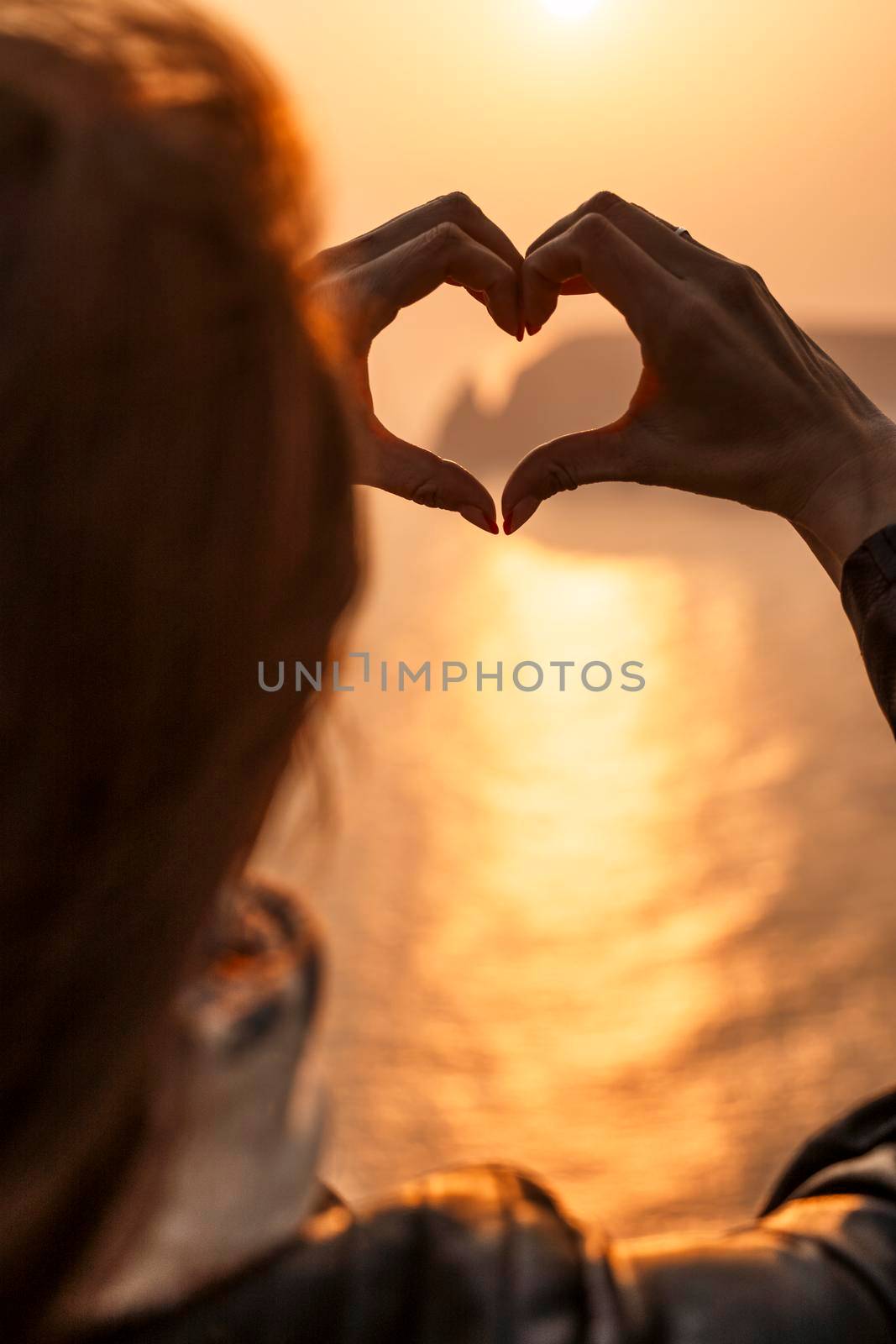 Women's hands symbol of the heart lifestyle and feelings concept with sunset light nature on a winter background. Valentine's day by Matiunina