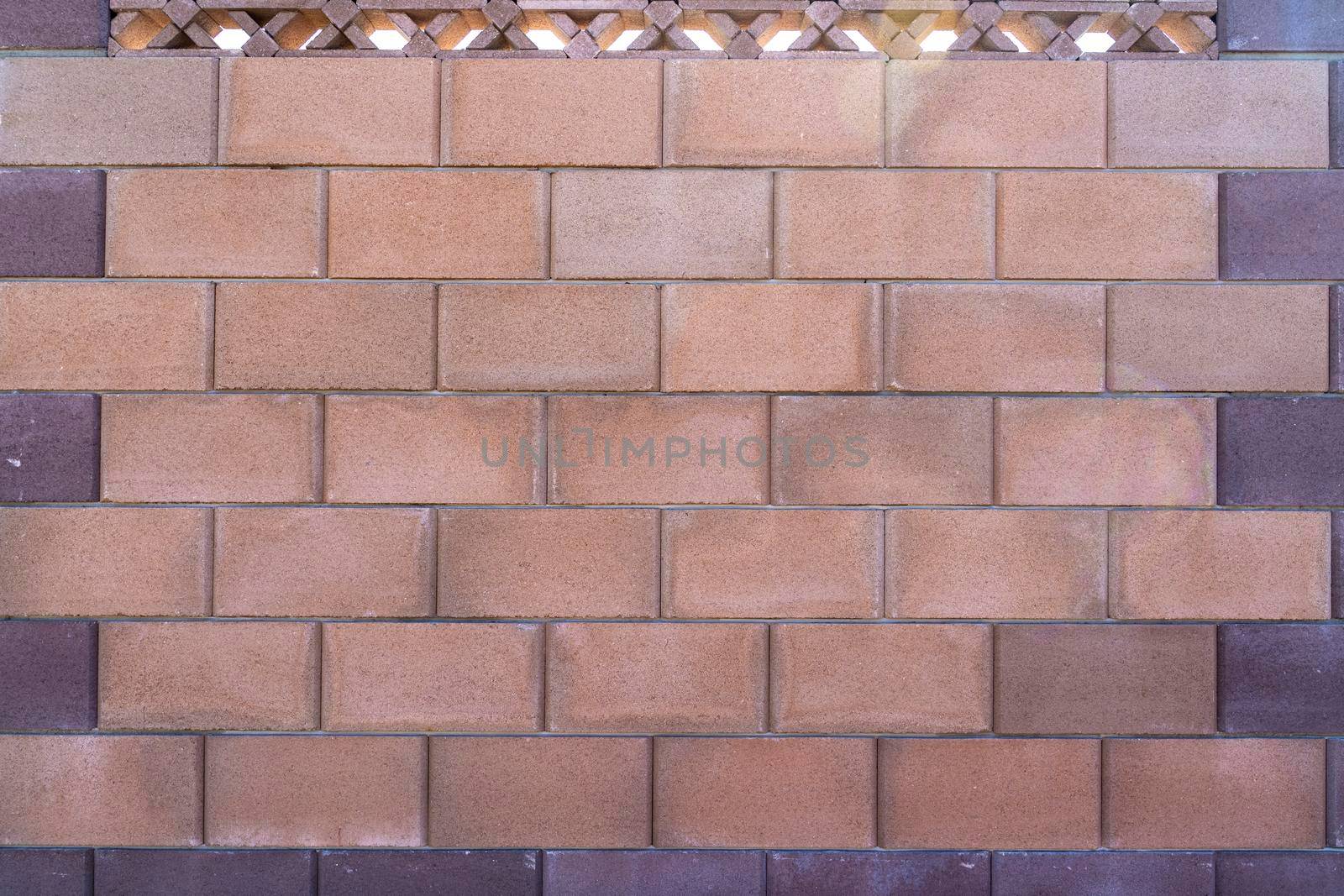 fence wall of colored bricks and gray stones on the street