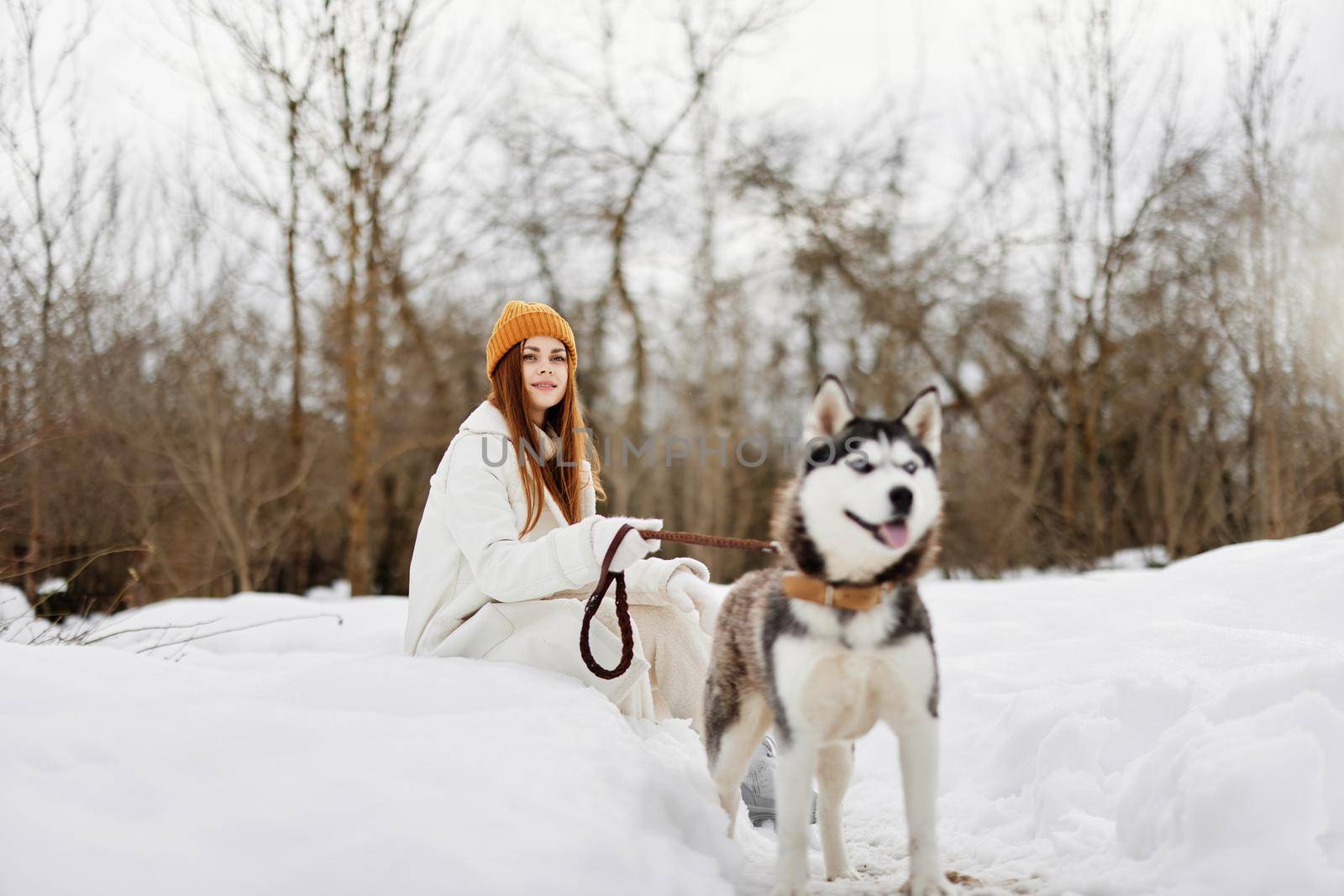 Happy young woman outdoors in a field in winter walking with a dog Lifestyle by SHOTPRIME