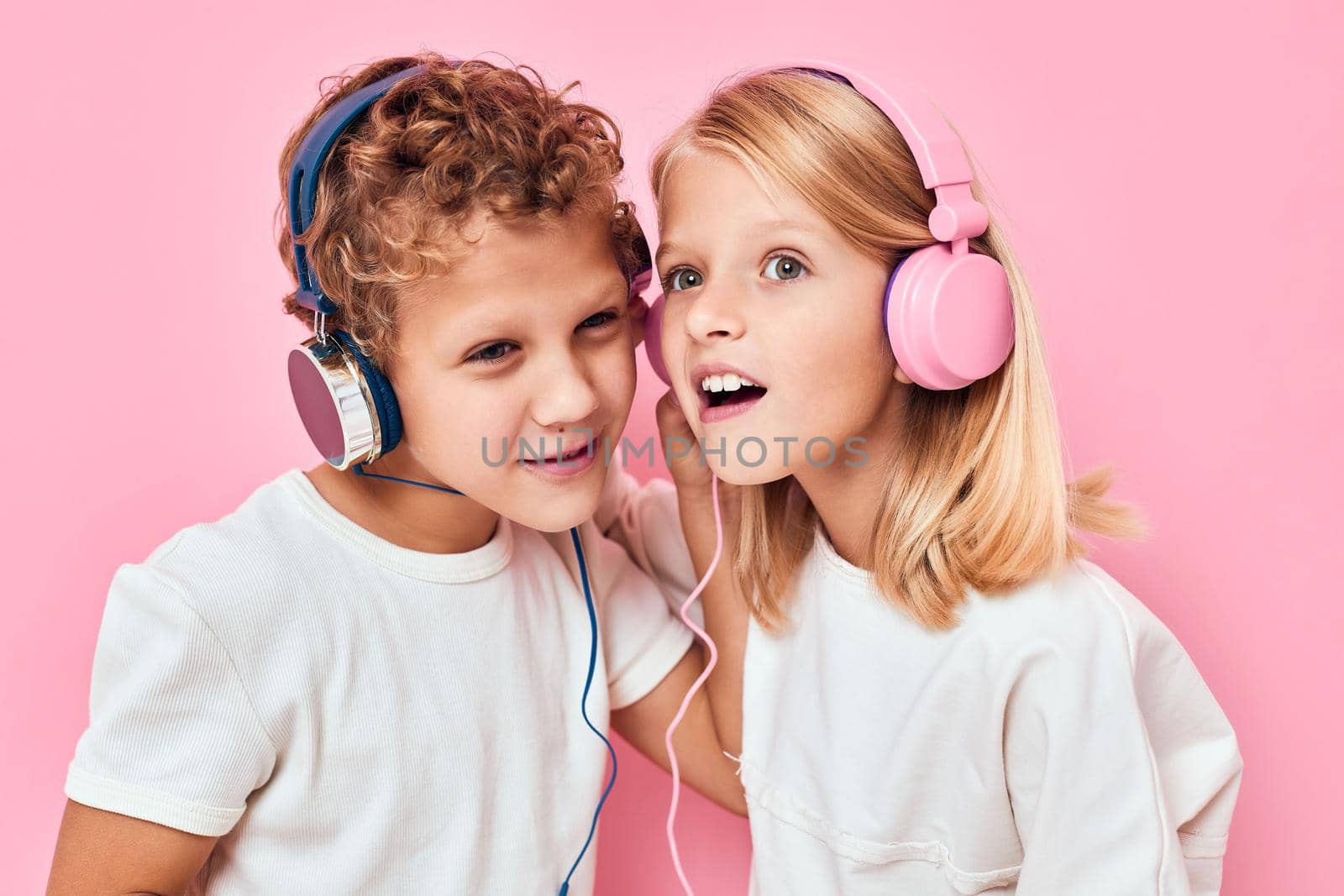 Stylish little boy and cute girl listening to music isolated background. High quality photo