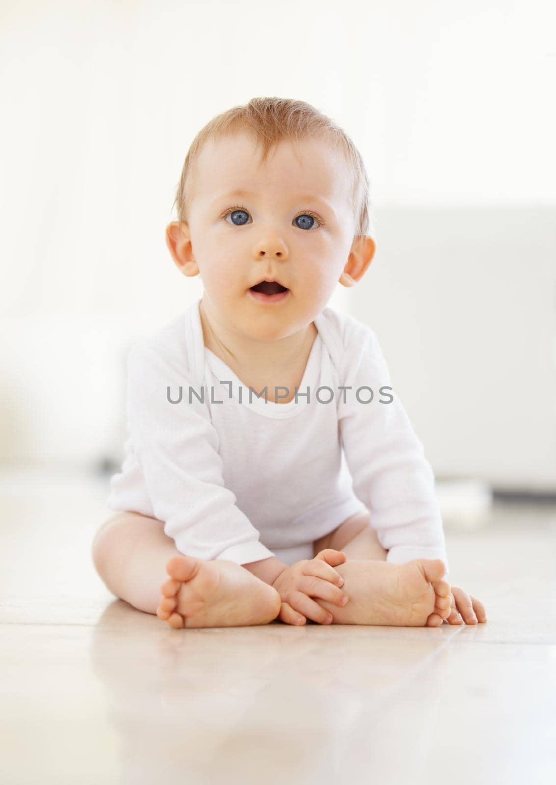 Time for look around I think. Shot of an adorable little baby sitting on the floor. by YuriArcurs