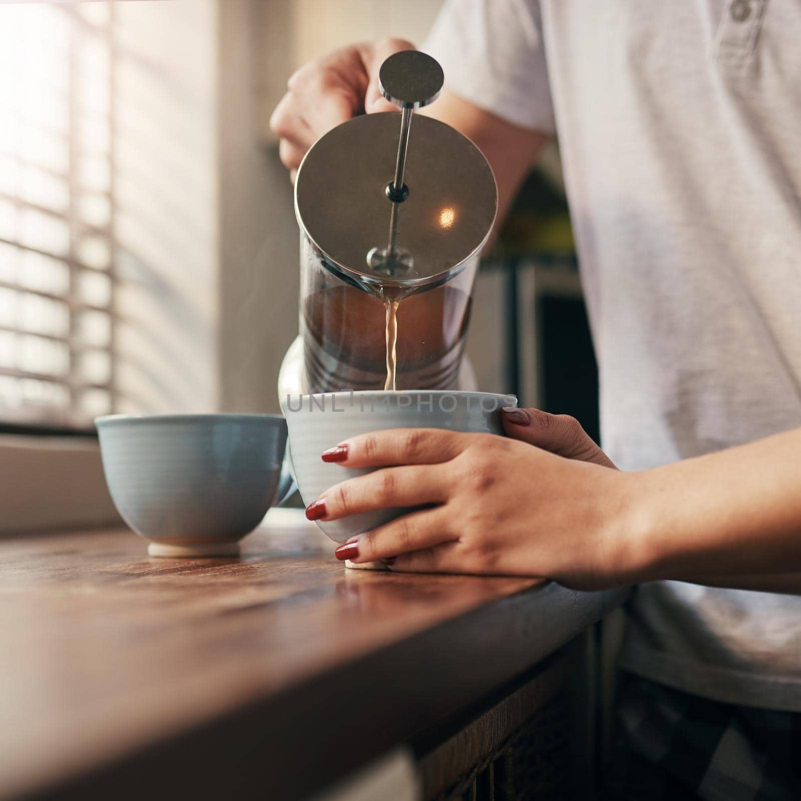 Cropped shot of an unrecognizable couple pouring their morning coffee.