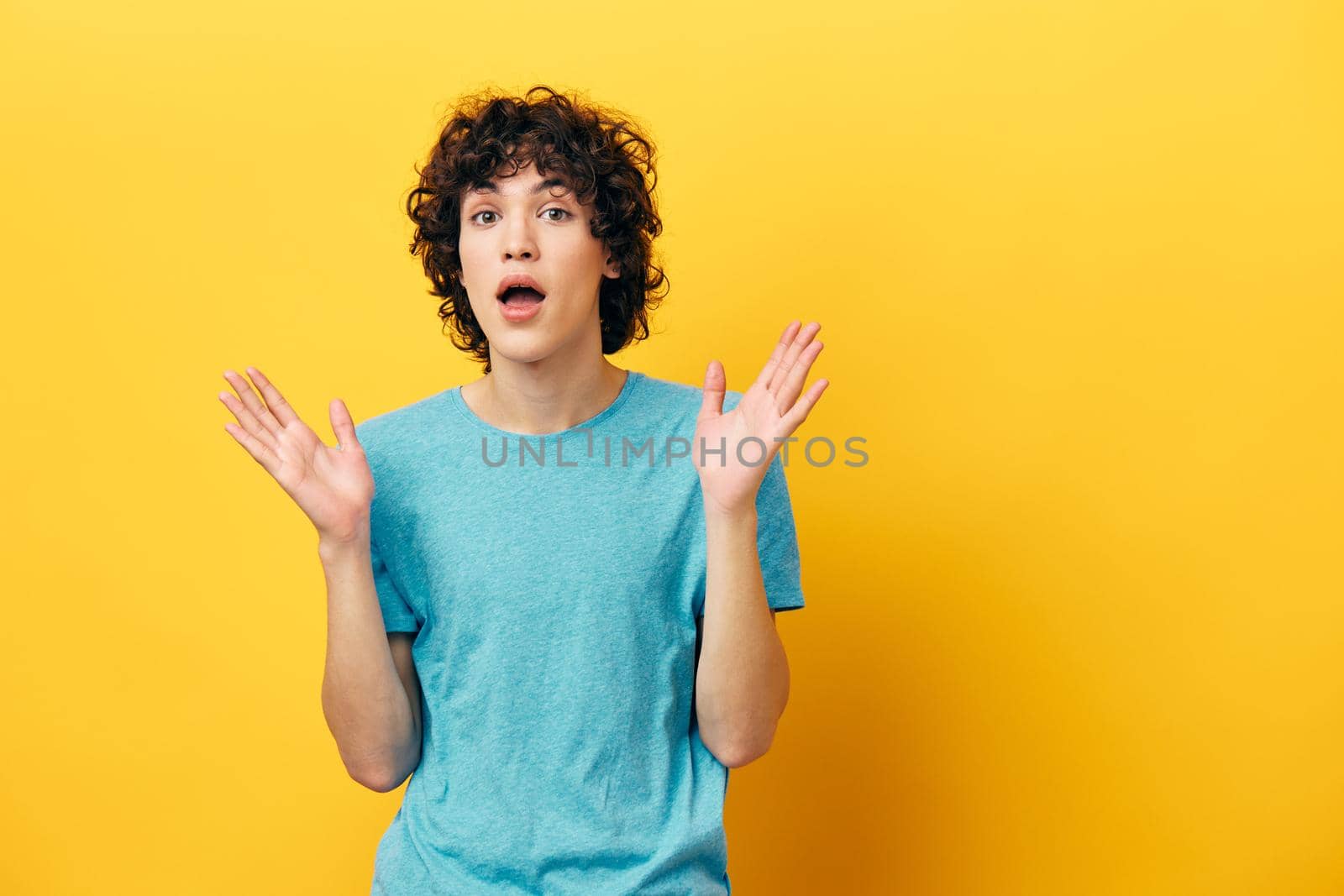 man in blue t-shirt shocked on yellow background. High quality photo