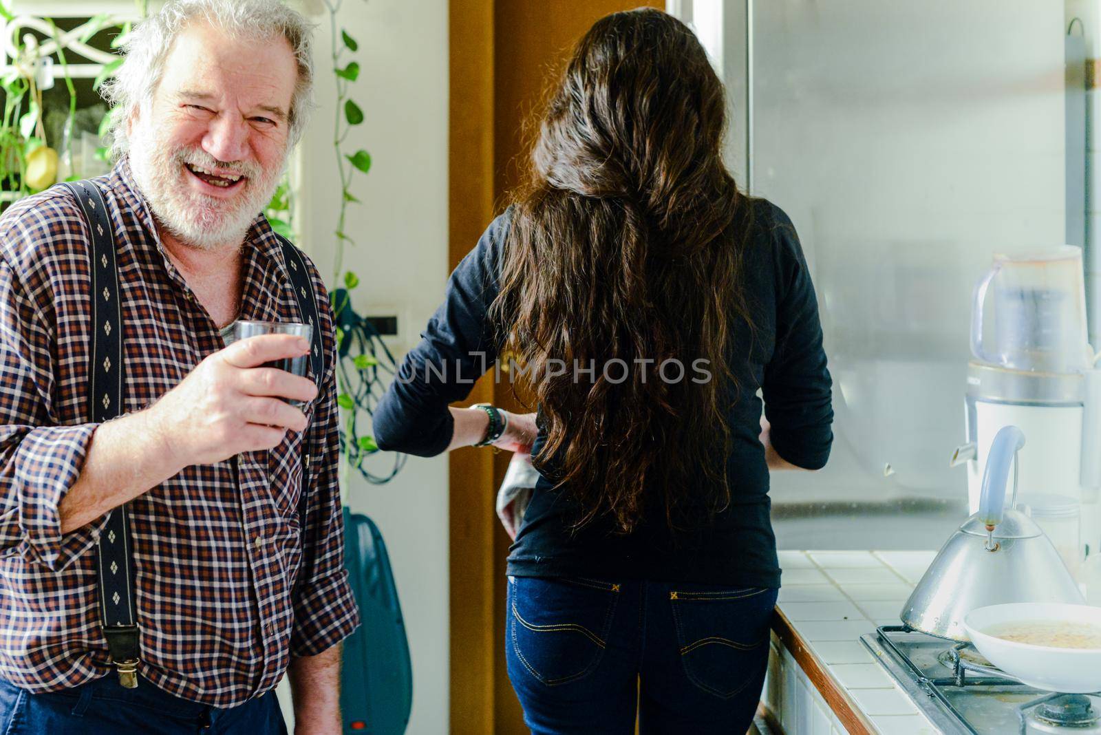 caucasian man drinking wine and getting drunk harassing young hispanic woman wife - alcoholism and domestic violence concept by verbano