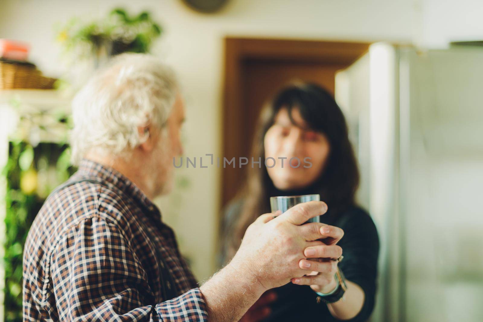 caucasian man drinking wine and getting drunk harassing young hispanic woman wife - alcoholism and domestic violence concept. High quality photocaucasian man drinking wine and getting drunk harassing young hispanic woman wife - alcoholism and domestic violence concept