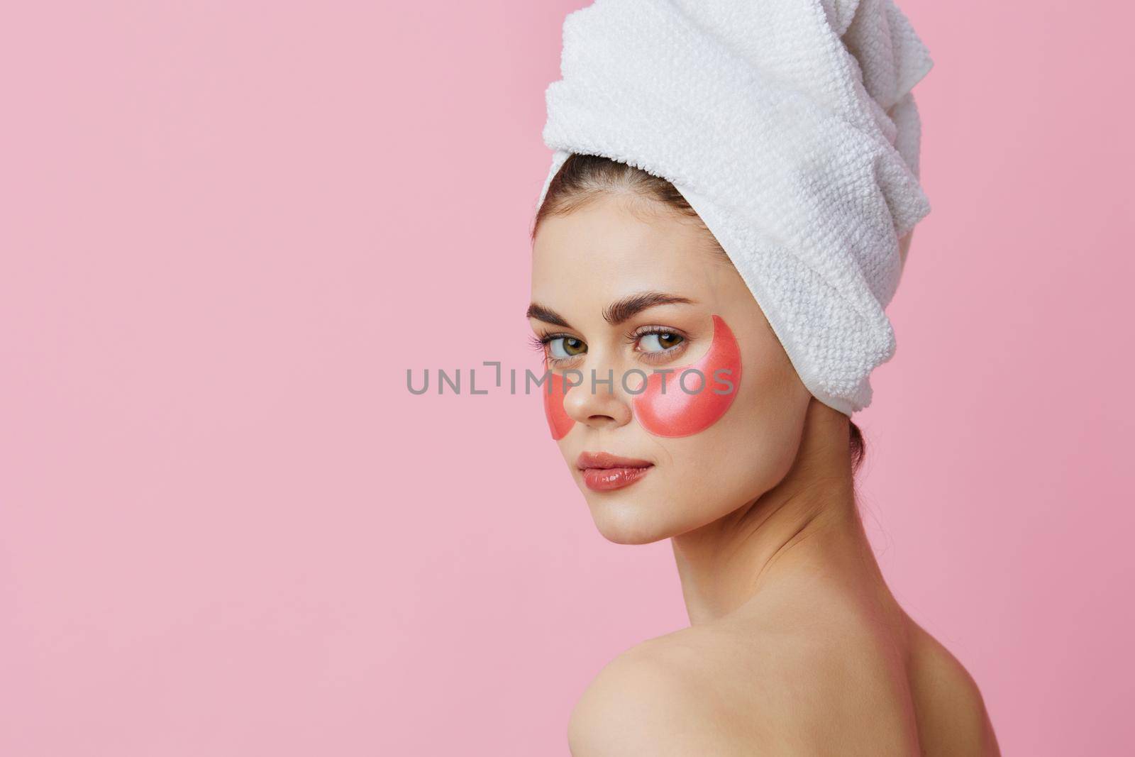 woman pink patches on the face with a towel on the head isolated background. High quality photo