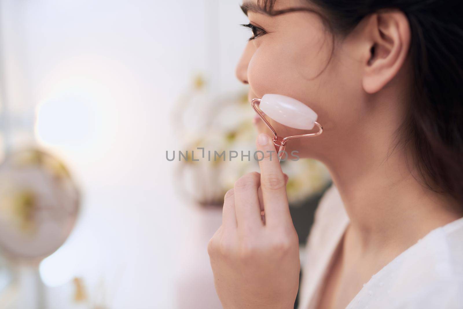 Woman caring of her beauty face with cosmetic tool