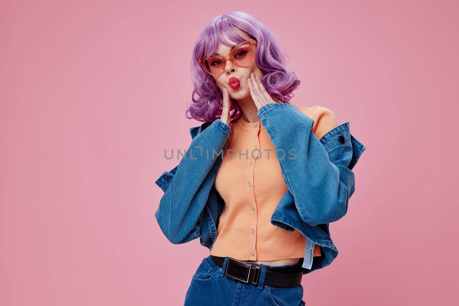 Beautiful fashionable girl purple hairstyle red lips denim jacket fun pink background unaltered. High quality photo