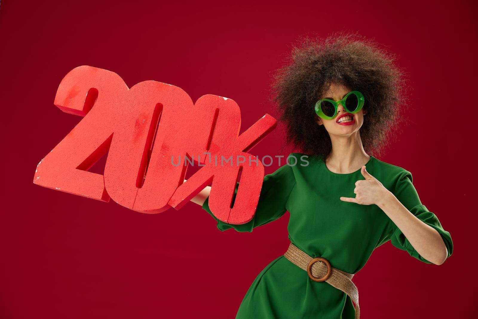 Beauty Fashion woman green dress afro hairstyle dark glasses twenty percent in hands color background unaltered. High quality photo