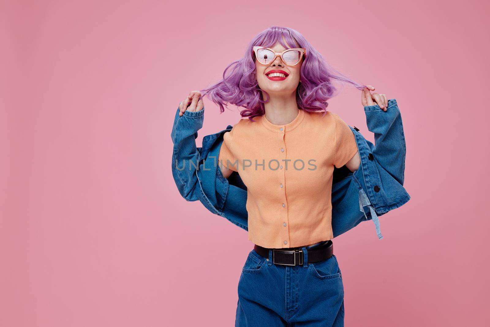 Beauty Fashion woman purple hair fashion glasses denim clothing pink background unaltered. High quality photo