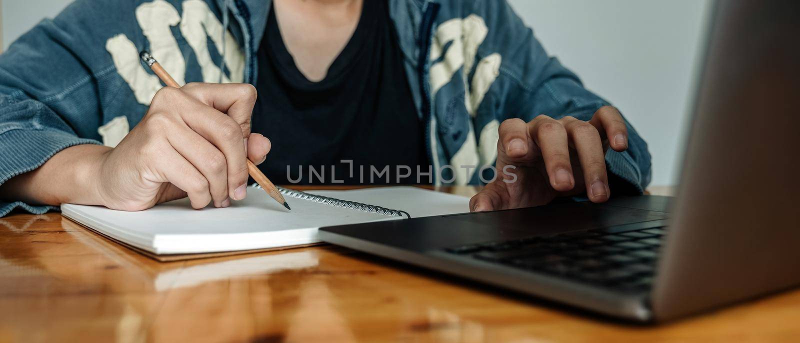 Cropped photo of woman writing making list taking notes in notepad working or learning on laptop indoors- educational course or training, seminar, education online concept.