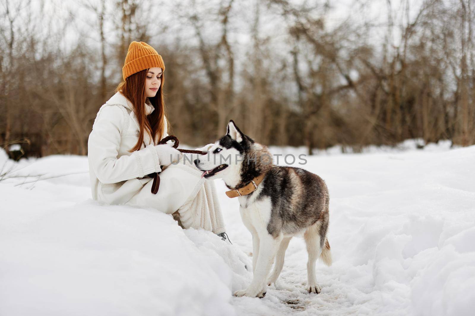 Happy young woman winter clothes walking the dog in the snow Lifestyle by SHOTPRIME