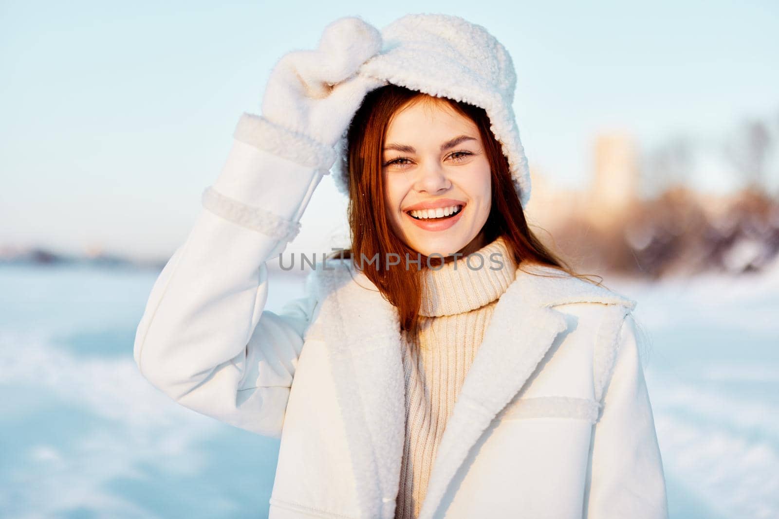 young woman in a white coat in a hat winter landscape walk nature. High quality photo
