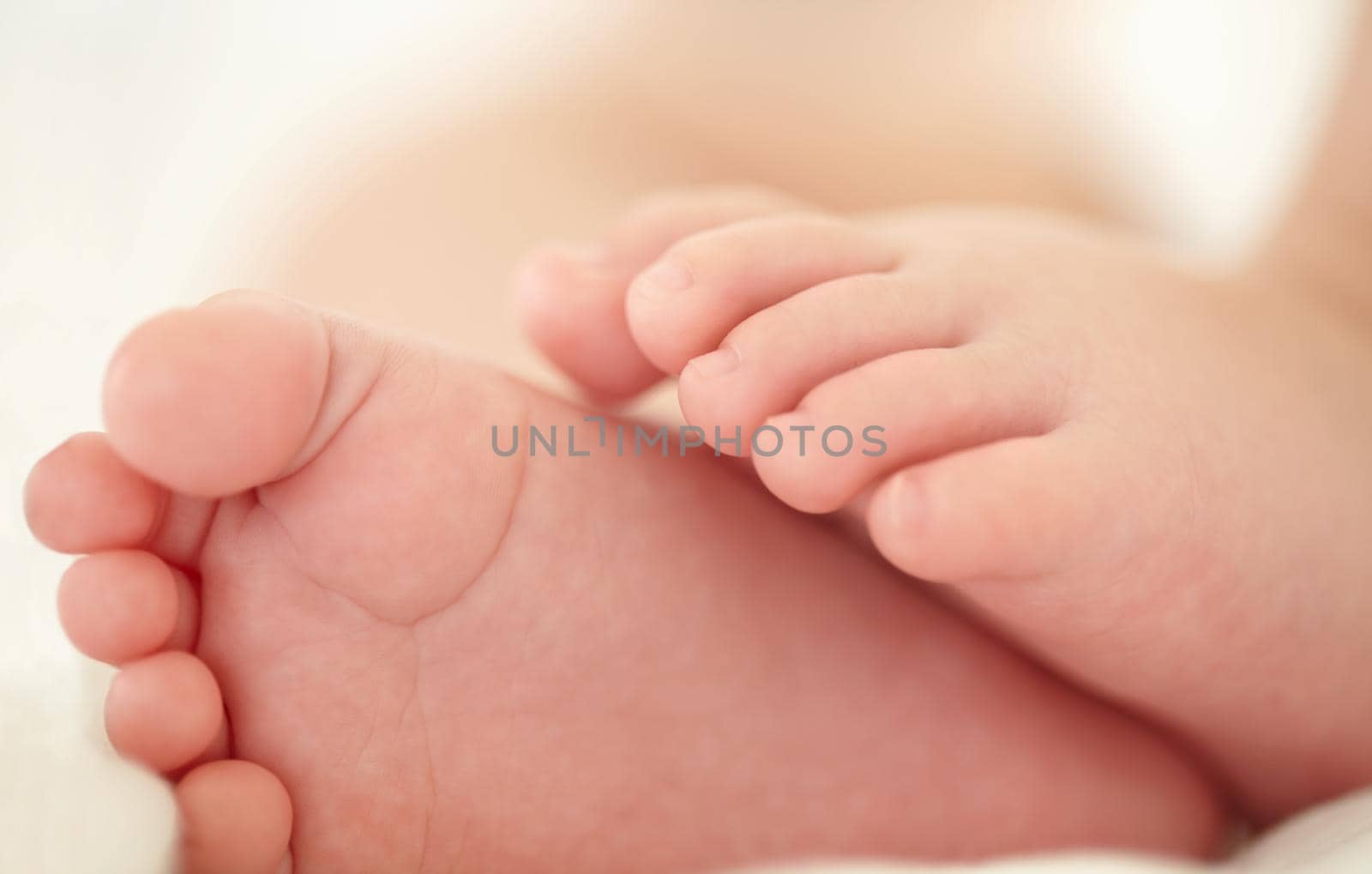 Soon these little feet will pitter-patter around the house. Cropped image of a babys feet. by YuriArcurs
