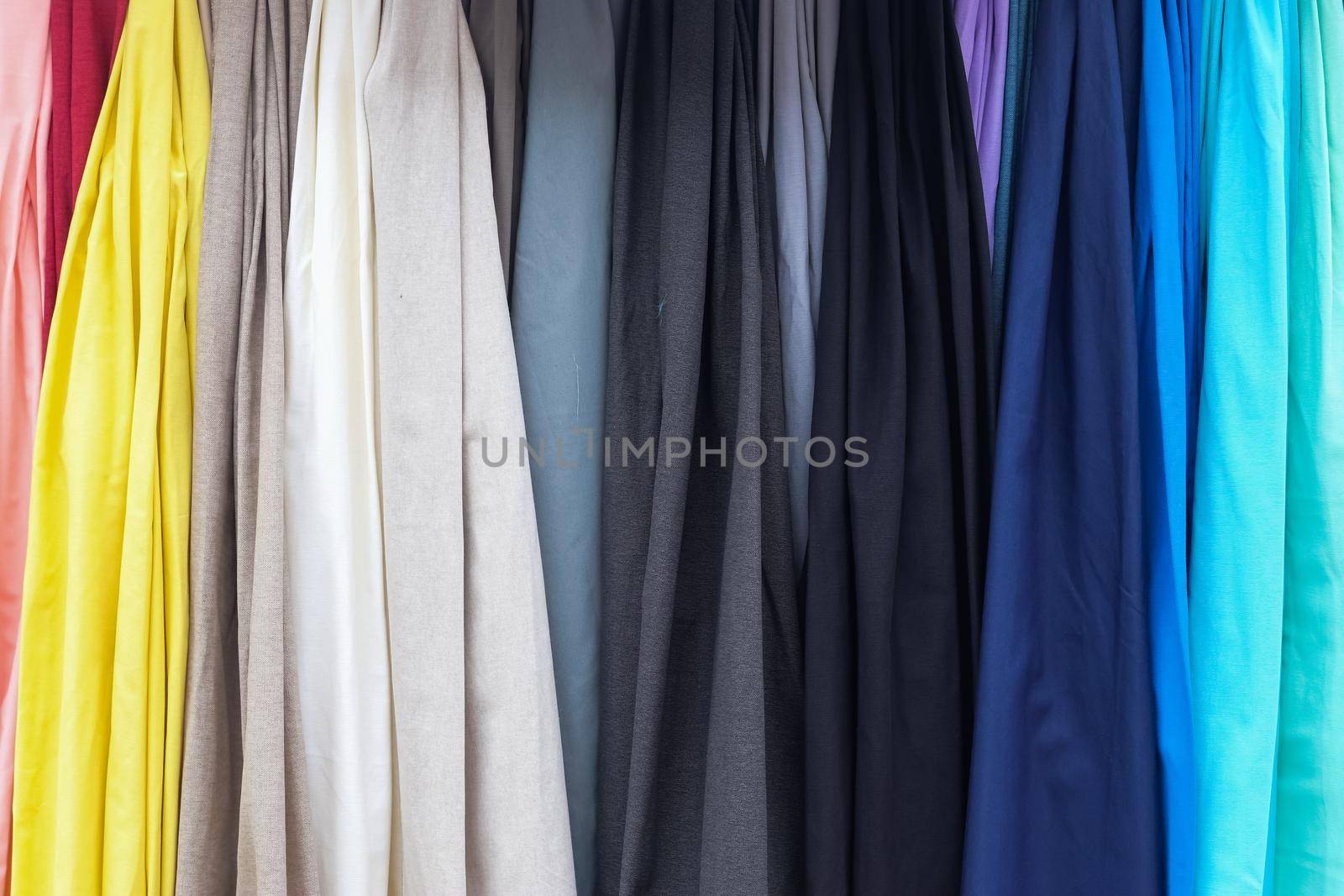 Detailed close up view on samples of cloth and fabrics in different colors found at a fabrics market.