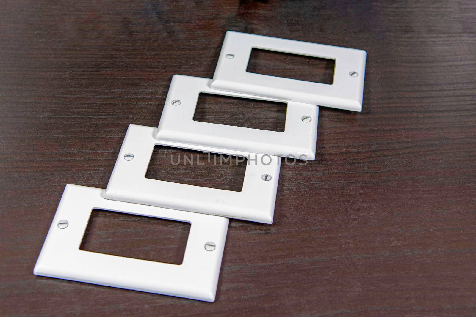 White plastic covers for electrical and switches and sockets lined up on a table