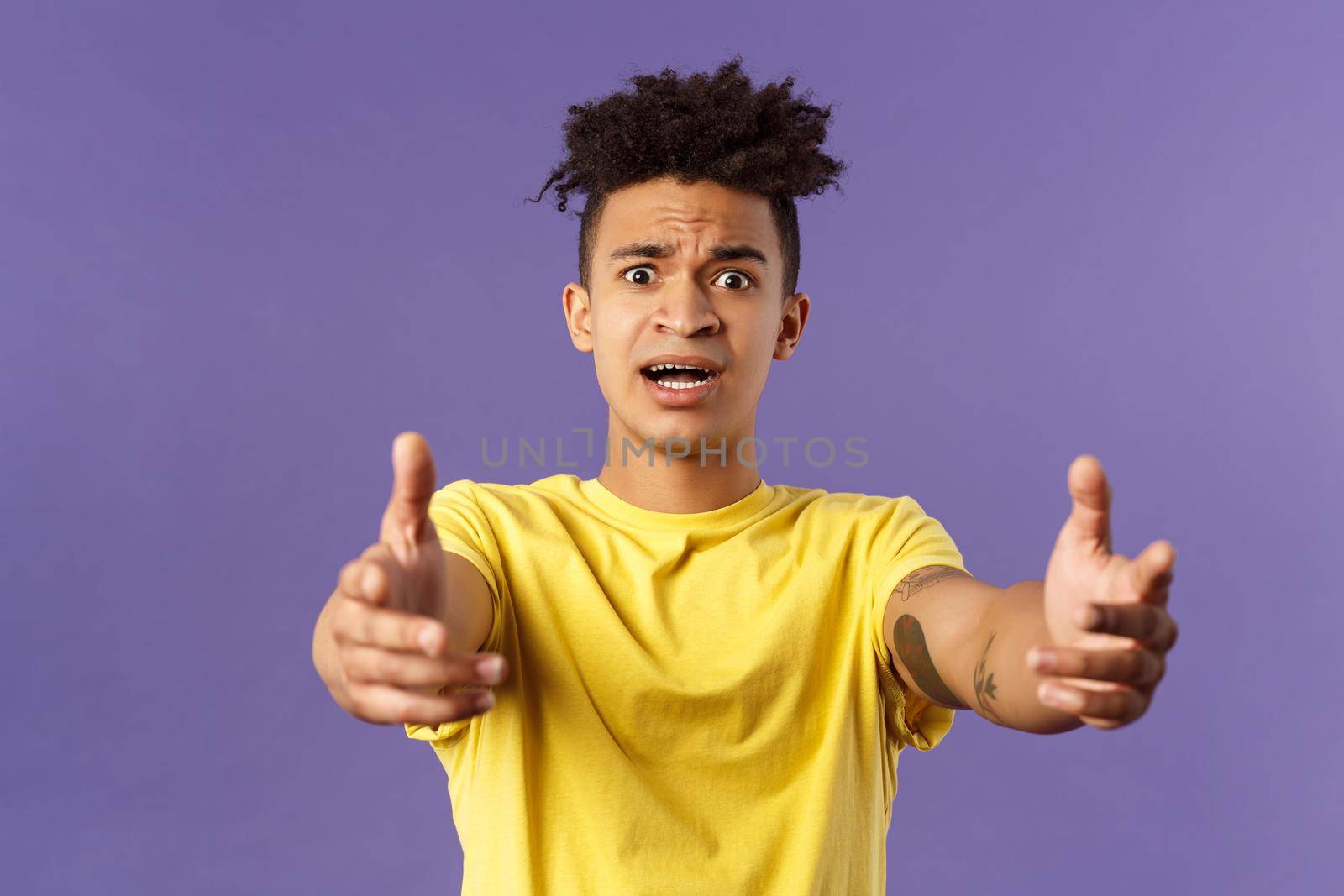 Waist-up portrait of concerned, nervous young man reaching hands forward to hold something but being scared, friend asking take baby for sec, standing very anxious and afraid, purple background by Benzoix