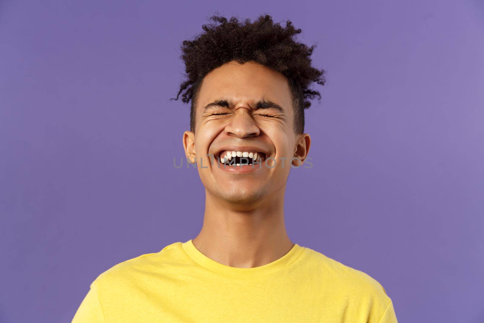 Close-up portrait of happy carefree young guy laughing loud, chuckling over hilarious joke, bending backwards and close eyes while giggle over funny movie, purple background by Benzoix