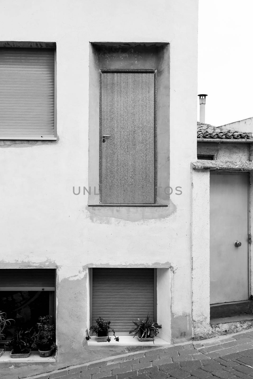 Abstract facade with nonsense and dangerous door on top without staircase in Benifato village, Alicante