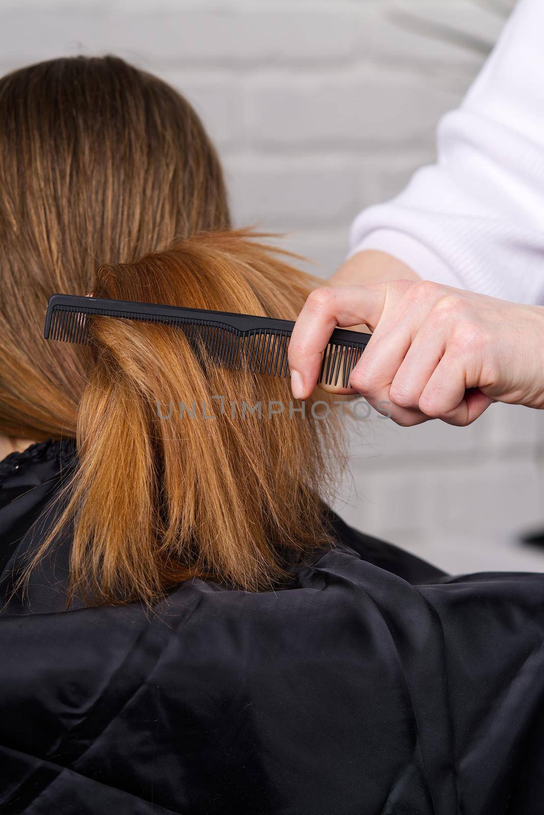Woman hair care. Hairdresser making hairstyle to young girl in beauty salon. by PhotoTime