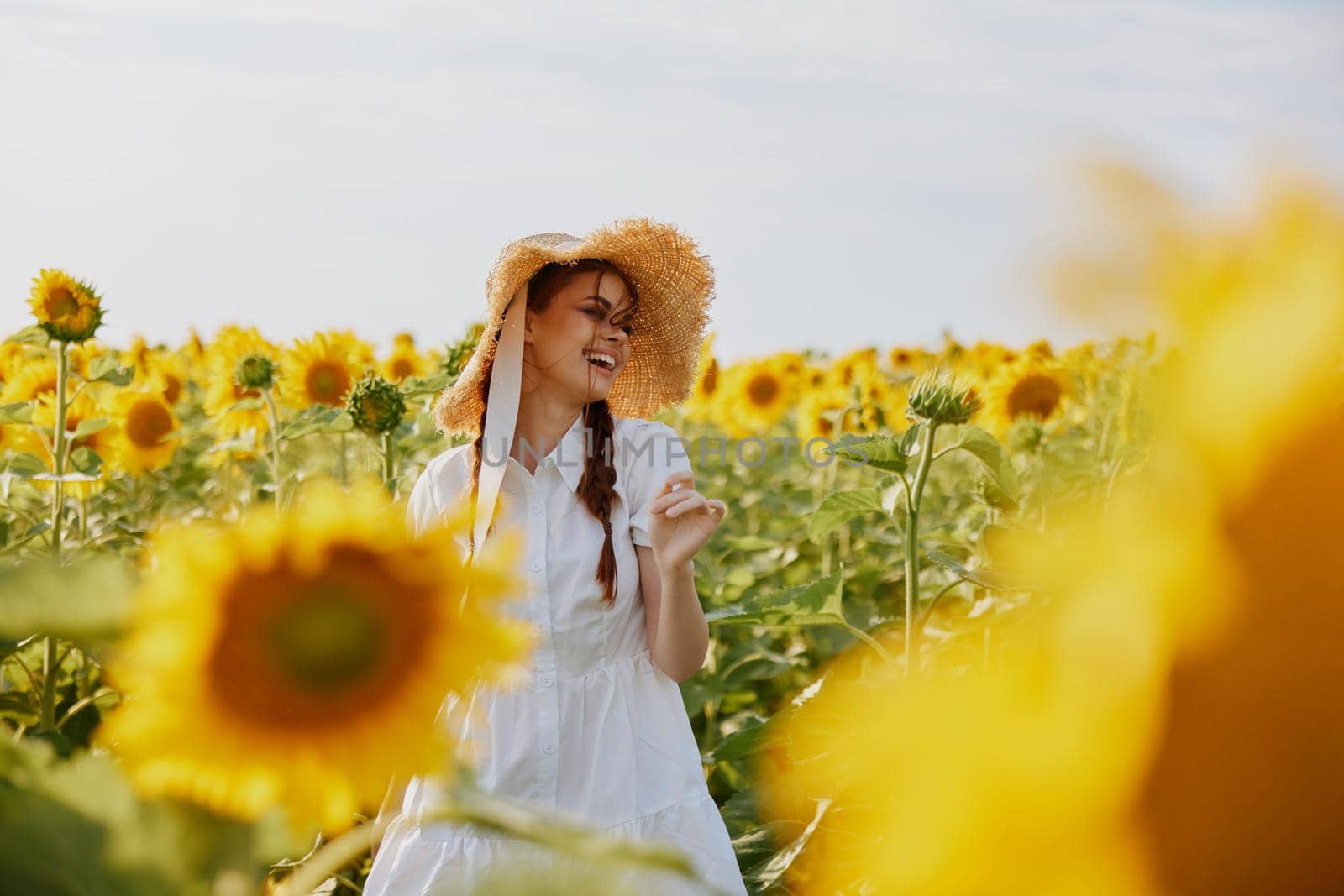 woman with two pigtails looking in the sunflower field countryside by SHOTPRIME