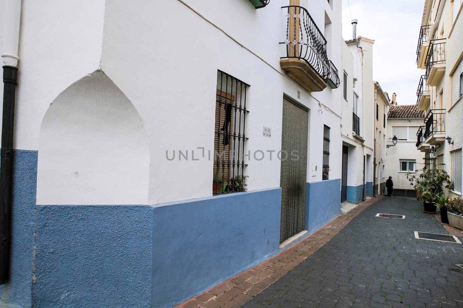 Benifato, Alicante, Spain- February 4, 2022: Narrow Street and typical facades of Benifato town on a cloudy day