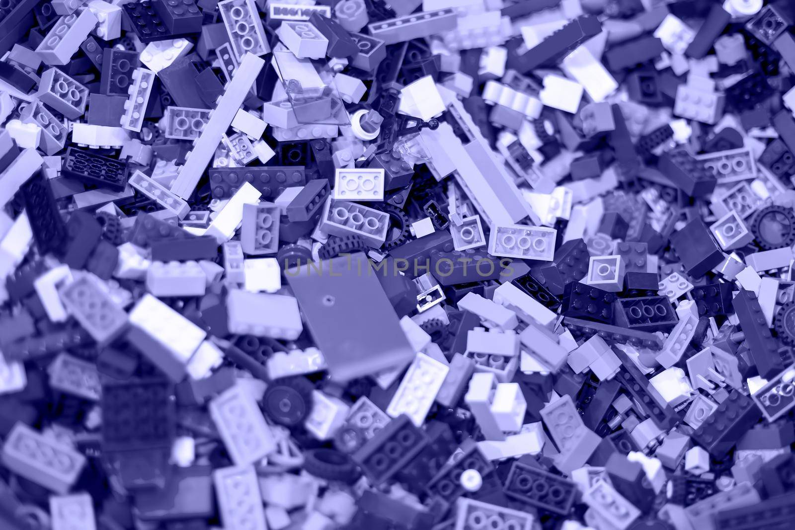 texture of colored toy bricks background. soft focus, top view toned very peri violet color
