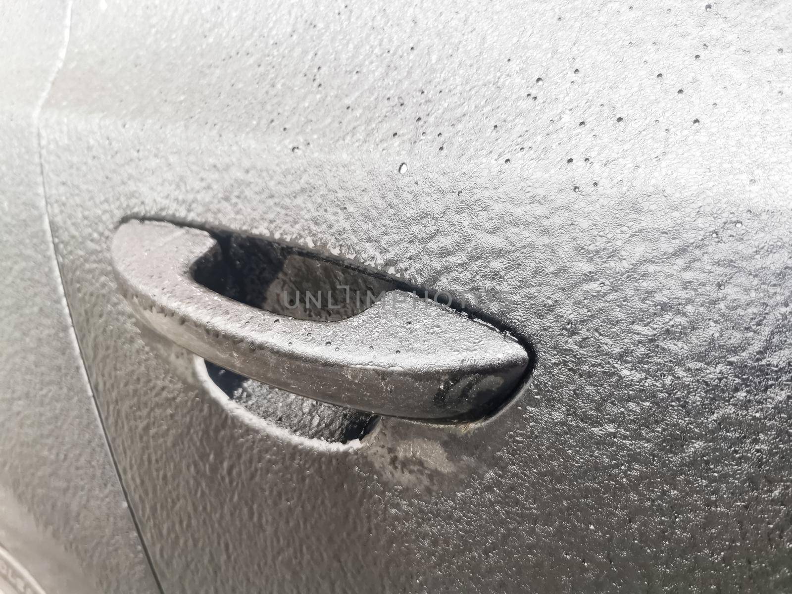 iced frozen car door handle close up silver colored