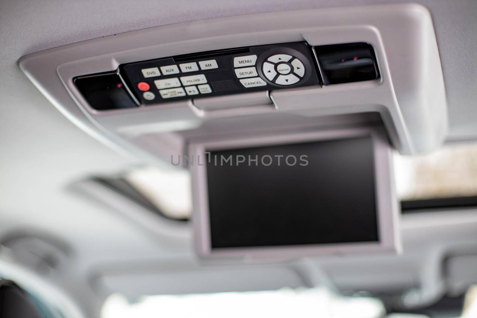 screen m multimedia system control panel on the ceiling of a modern car. close-up by Mariaprovector