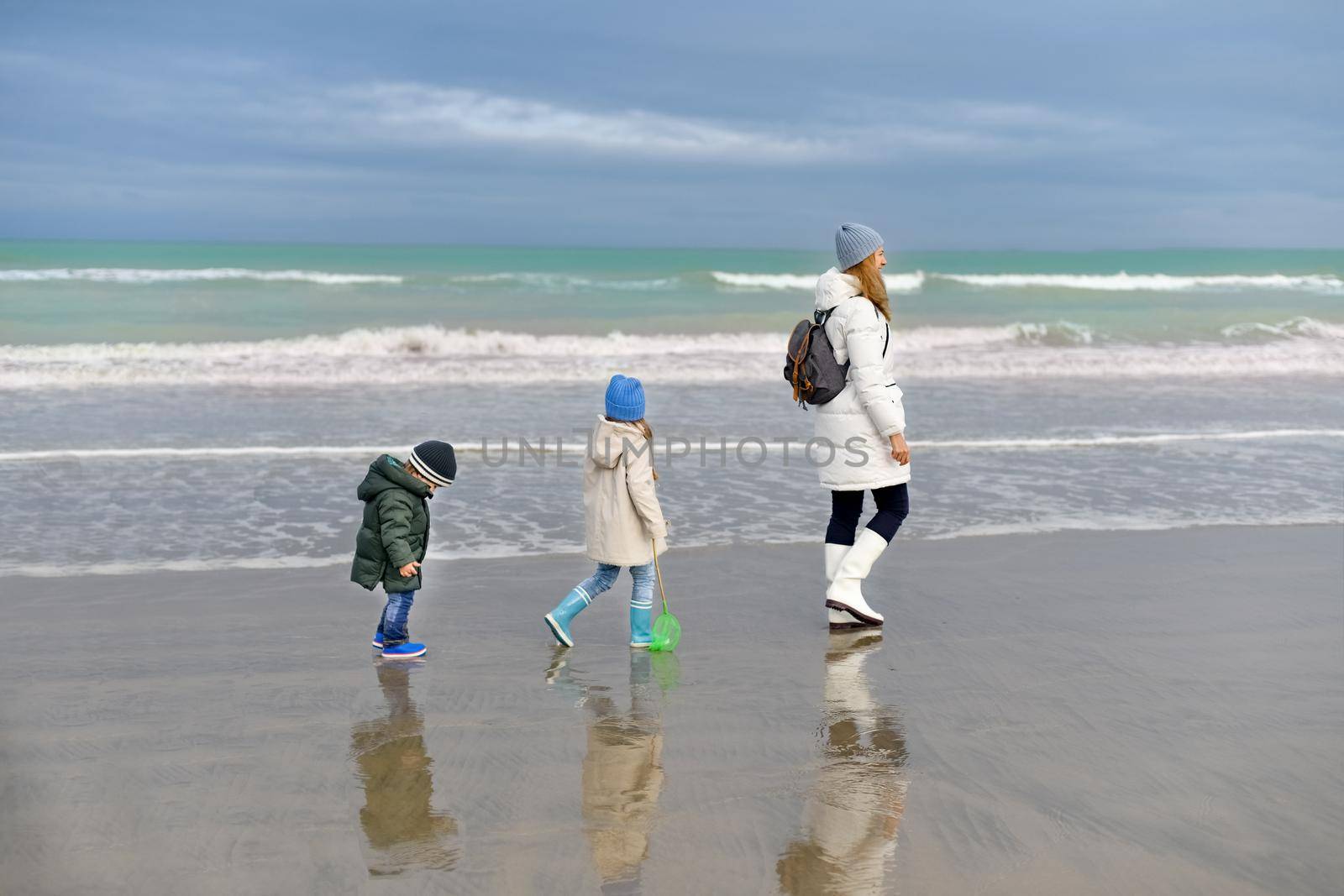 Mother and her children walking along at Atlantique ocean