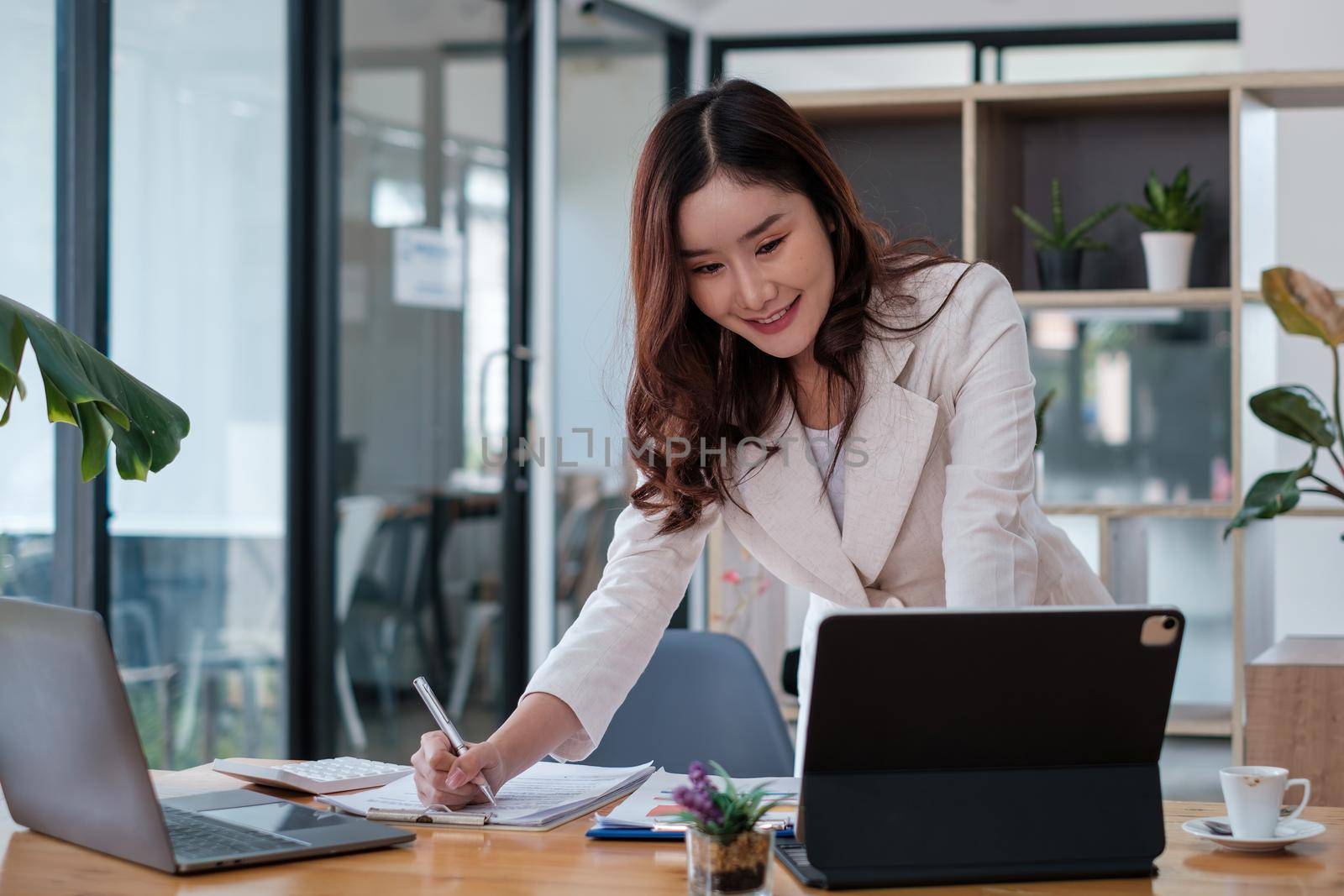 Asian business woman having video call with business team to consult about business plan of company. Online team meeting video conference