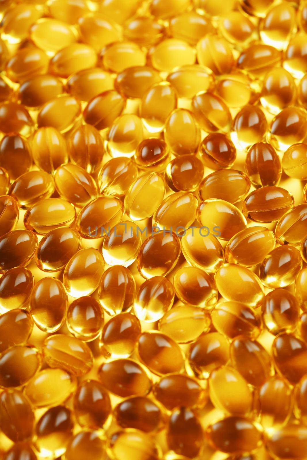 Golden Vitamin D3 Capsules close-up in full screen by AlexGrec