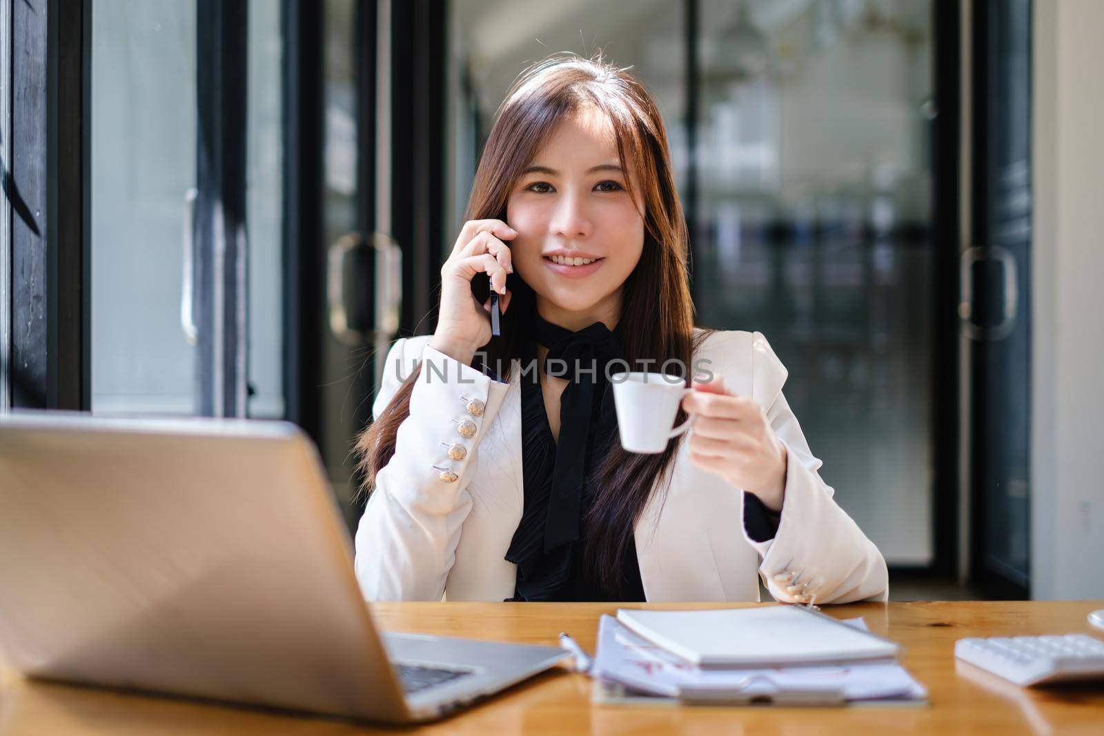 Asian Business woman working to analyze technical price graph and indicator with business team talking by cell phone. account or saving money or insurance concept. by itchaznong