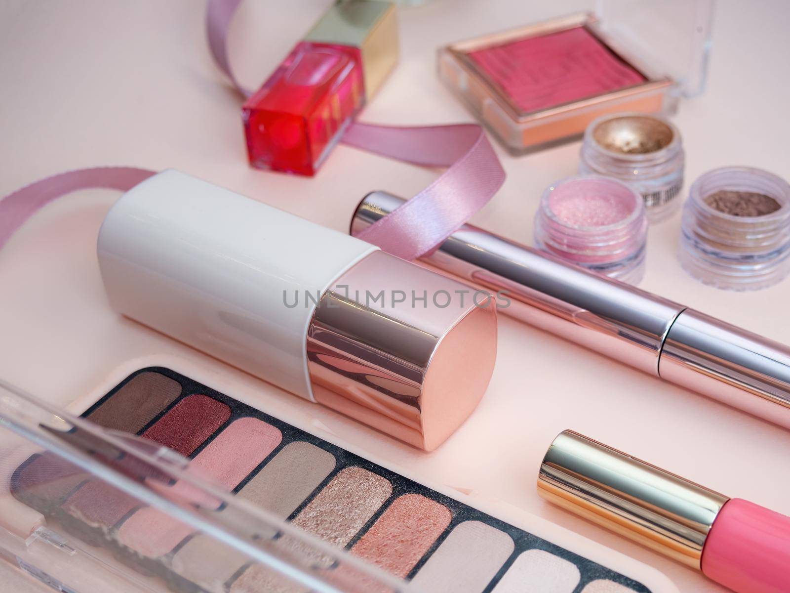 set of beauty cosmetics for female face and eye makeup on pink background . photo